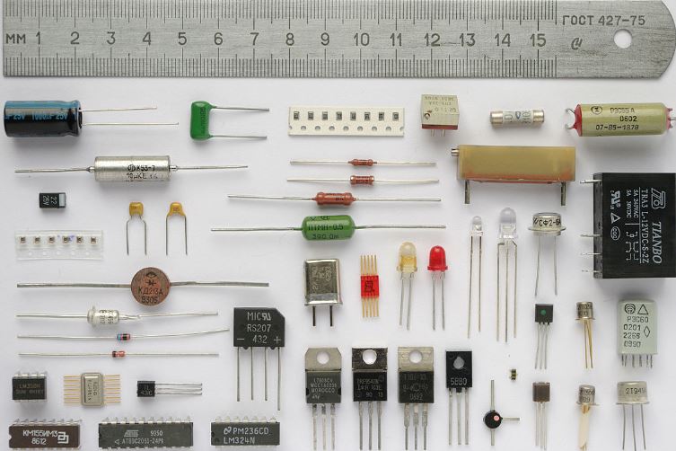 photo of various electronic components laid out on a table next to a ruler for scale
